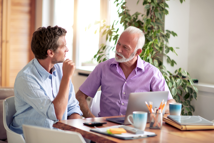 A senior client meeting with a financial advisor to discuss tax-deductible health insurance premiums.