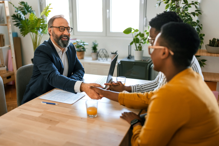 A couple sitting down with their financial advisor to figure out how much money they should have saved by age 45. 