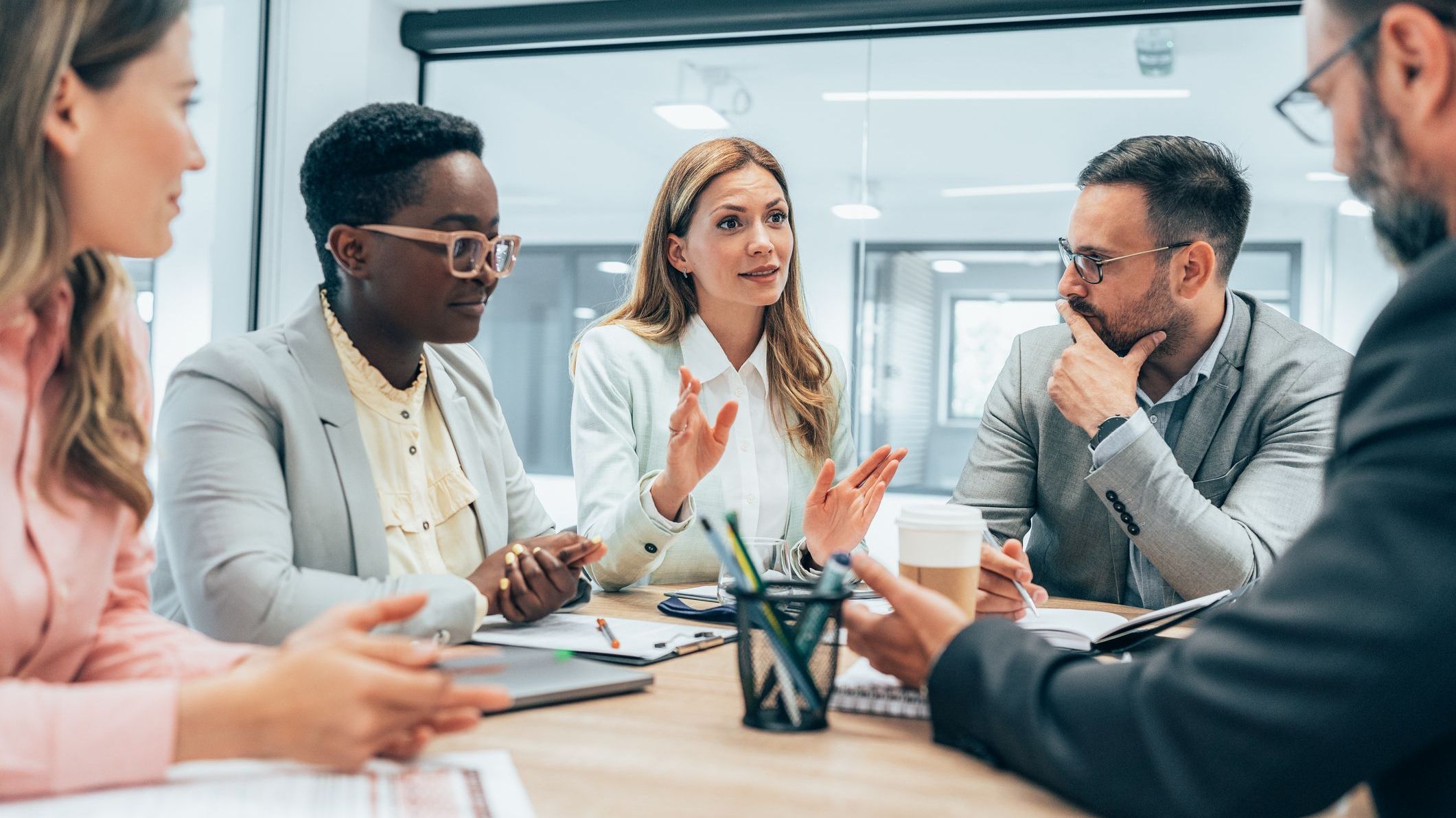 A business owner meets with her employeee to discuss the company's safe harbor 401(k) matching. 