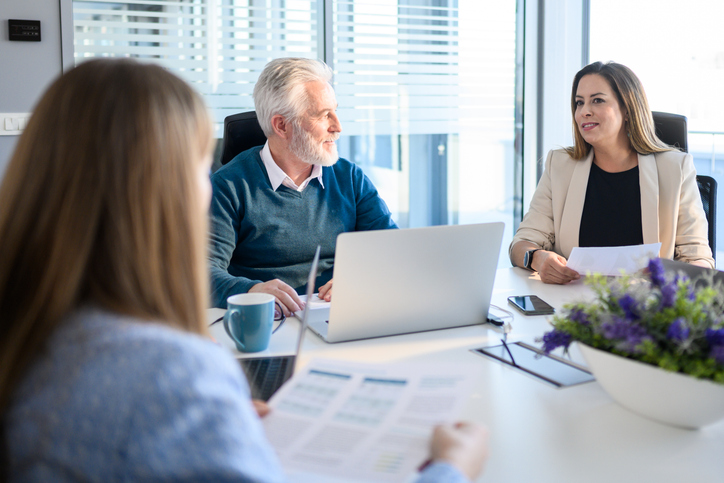 A senior couple meeting with a financial advisor to discuss a rollover IRA.