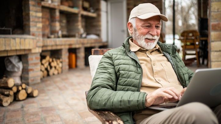 A retiree sits on his patio and reviews his IRA balance and holdings. 