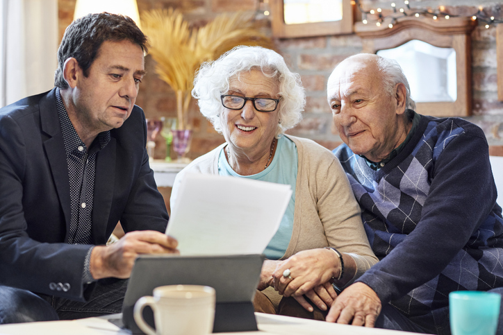 A senior couple meeting with a financial advisor to ask about a Roth conversion.